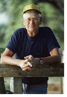 Senior man leaning on a fence